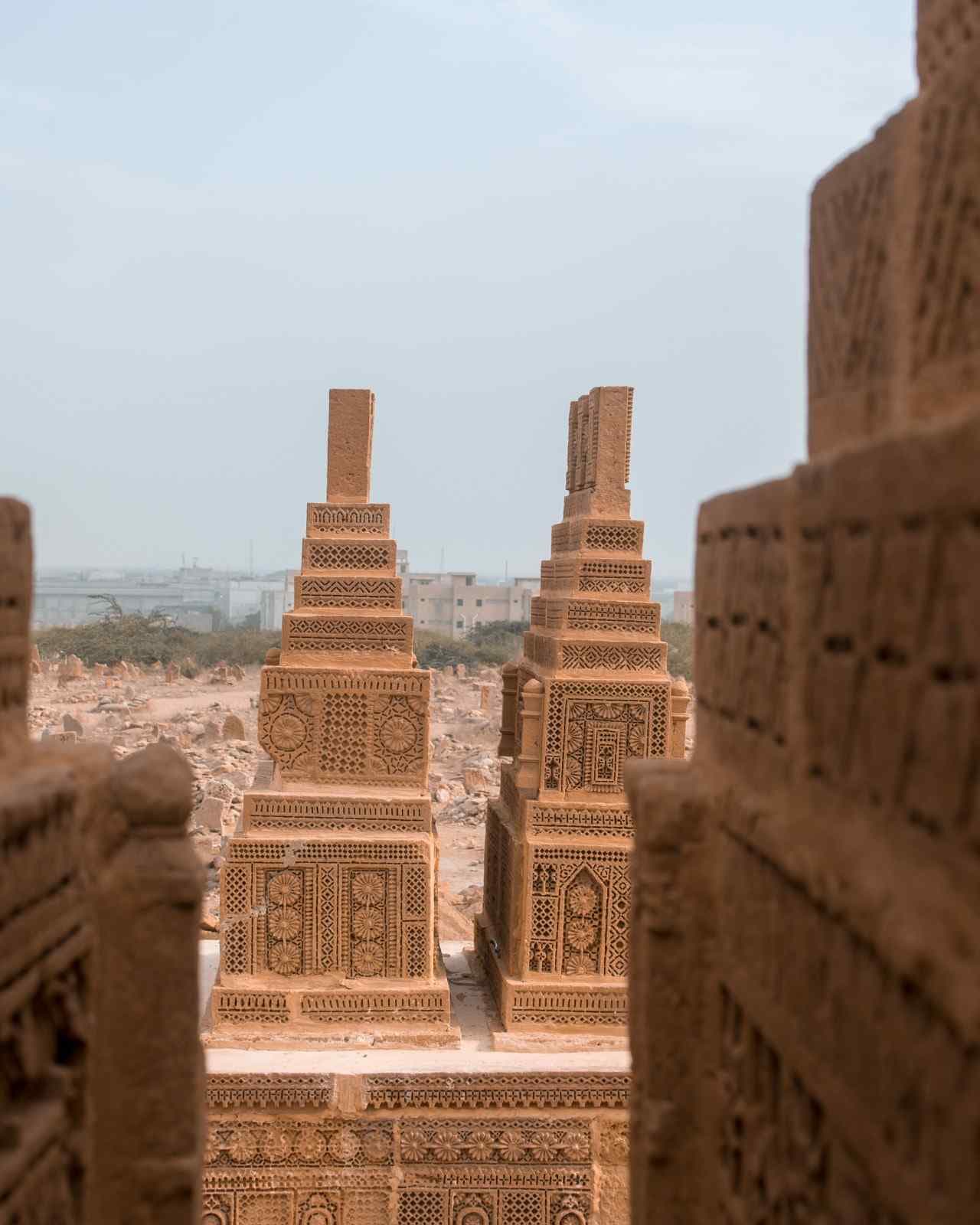 Two richly carved sandstone graves seen between other tombs
