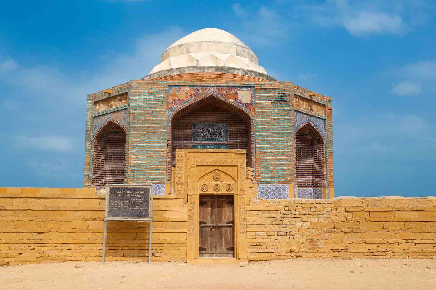 Domed tomb with blue glazed tiles and a carved doorway